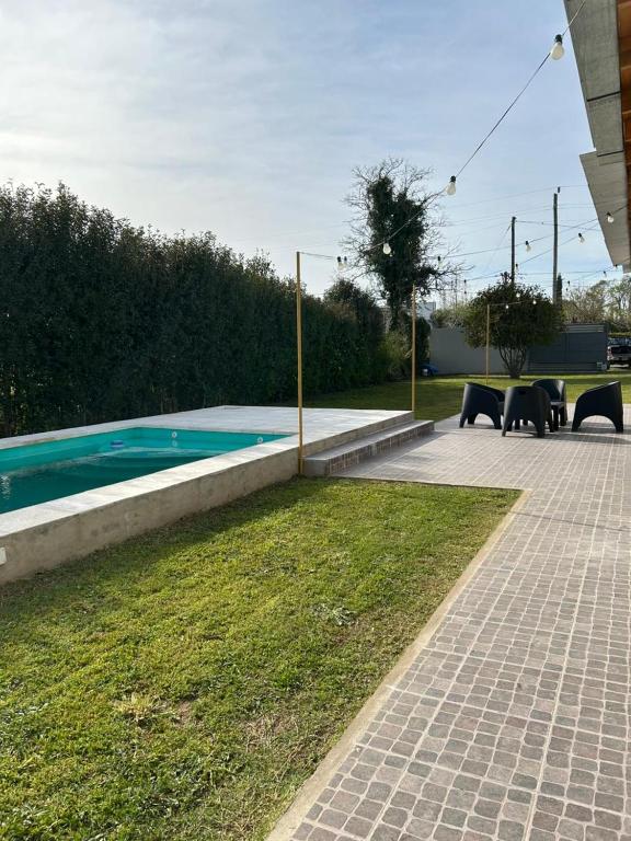 a swimming pool in a yard with tables and chairs at Quinta Las Lilas in Chivilcoy