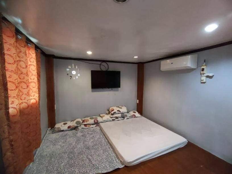 a small bedroom with a bed and a tv at casa house baler transient in Baler