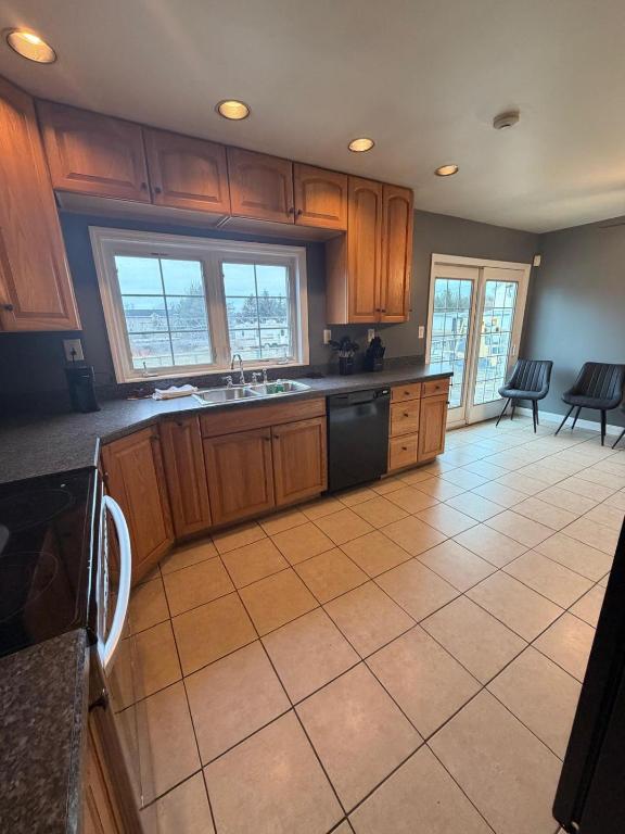 a kitchen with wooden cabinets and a tile floor at Get Away Casino in Bensalem