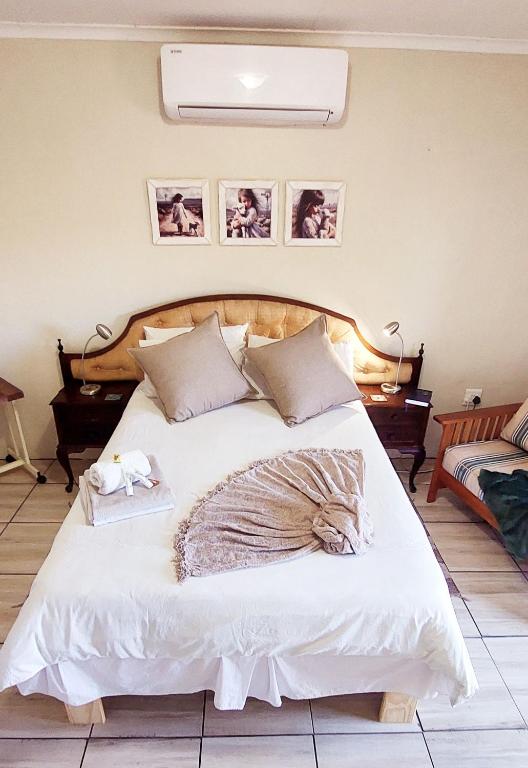 a bedroom with a large white bed with two towels at Karoo-Koppie in Colesberg