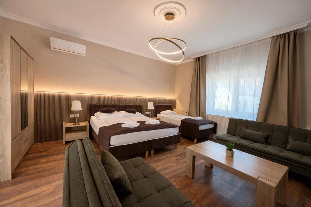a hotel room with a bed and a couch at Honti Apartmanház in Visegrád