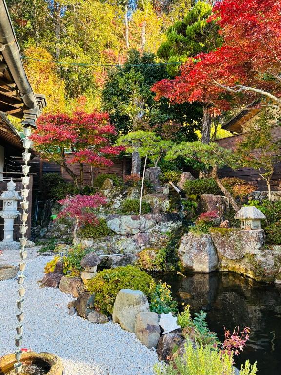 a garden with a pond and rocks and trees at Guest house Mitaki in Hiroshima