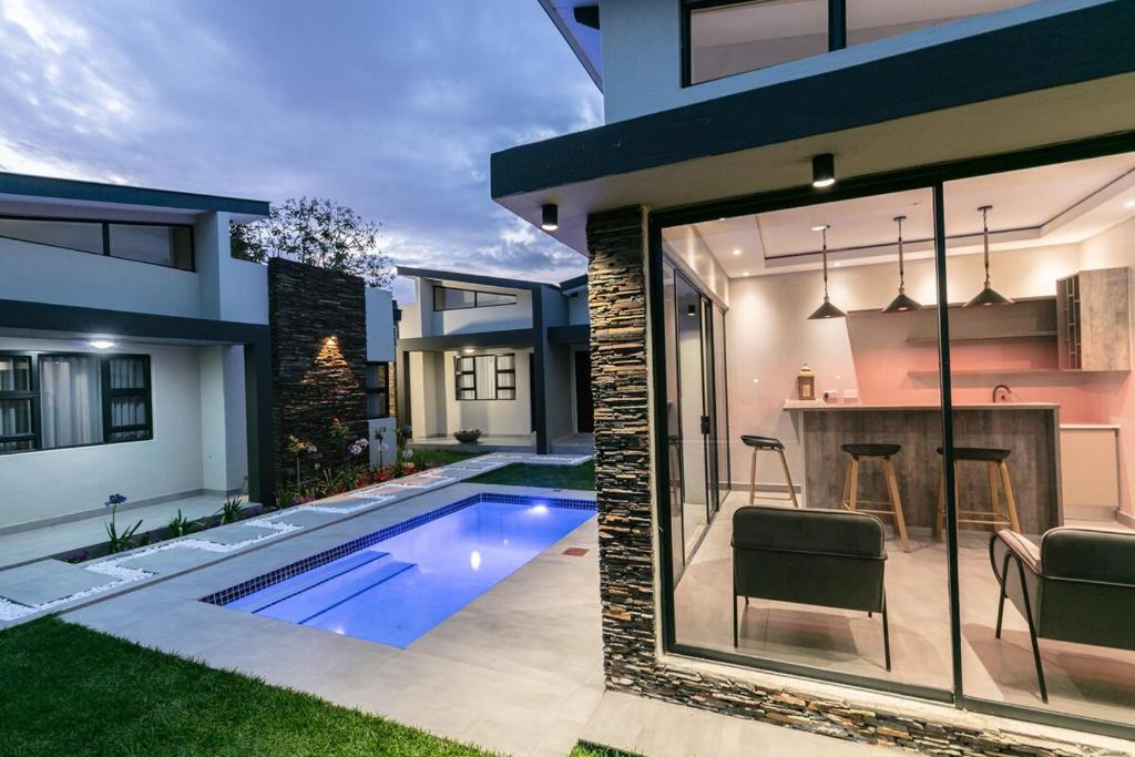 a house with a swimming pool in a yard at Ditsametse Luxe Suites in Gaborone