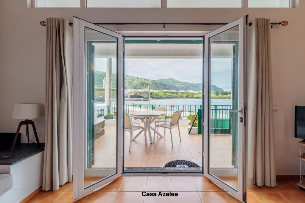 a sliding glass door leading to a patio with a table at Casas do Porto - Azalea and Hortênsia in Mosteiros