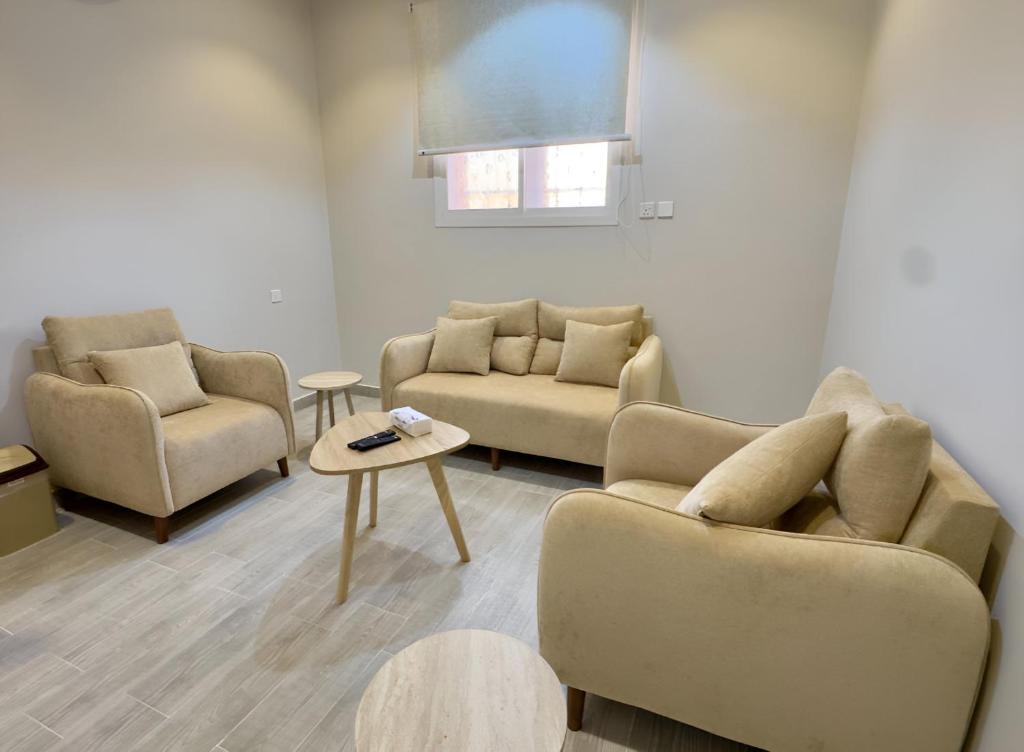 a living room with two couches and a table at Alturya in Al-ʿUla