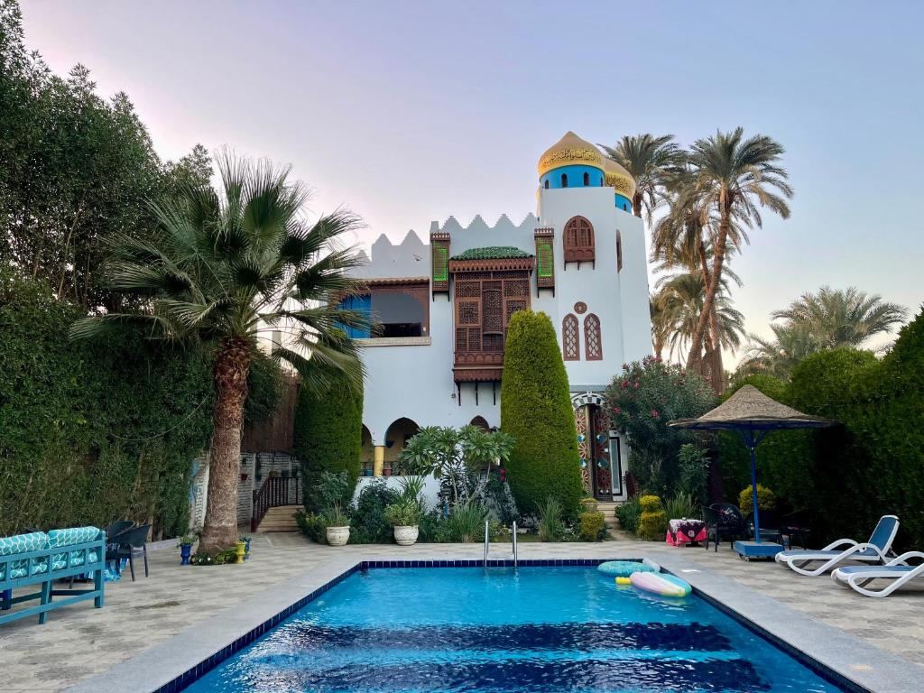 a house with a swimming pool in front of a house at Villa Barba Luxor in Luxor