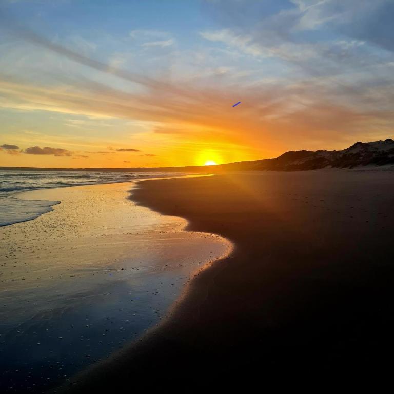 a sunset on a beach with the ocean at Guests at 32 Nautilus Bay in Dana Bay