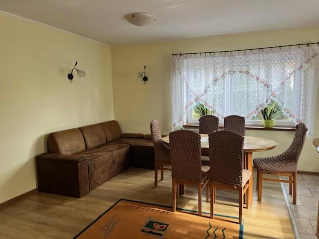 a living room with a table and chairs and a couch at But in Pasłęk