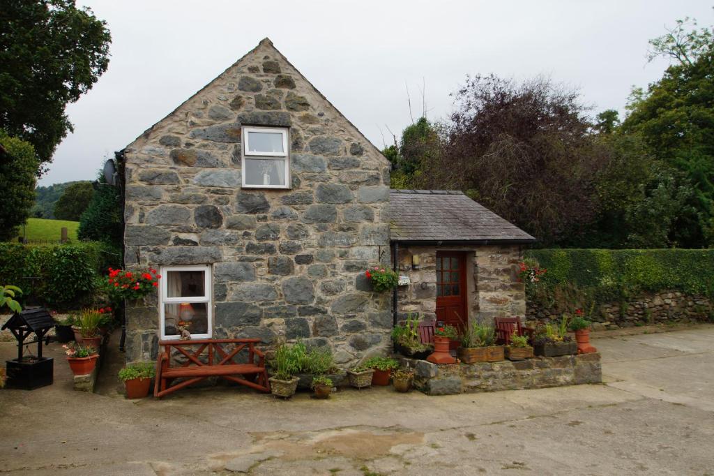 コンウィにあるBwthyn Conwyの窓とテーブルのある小さな石造りの家