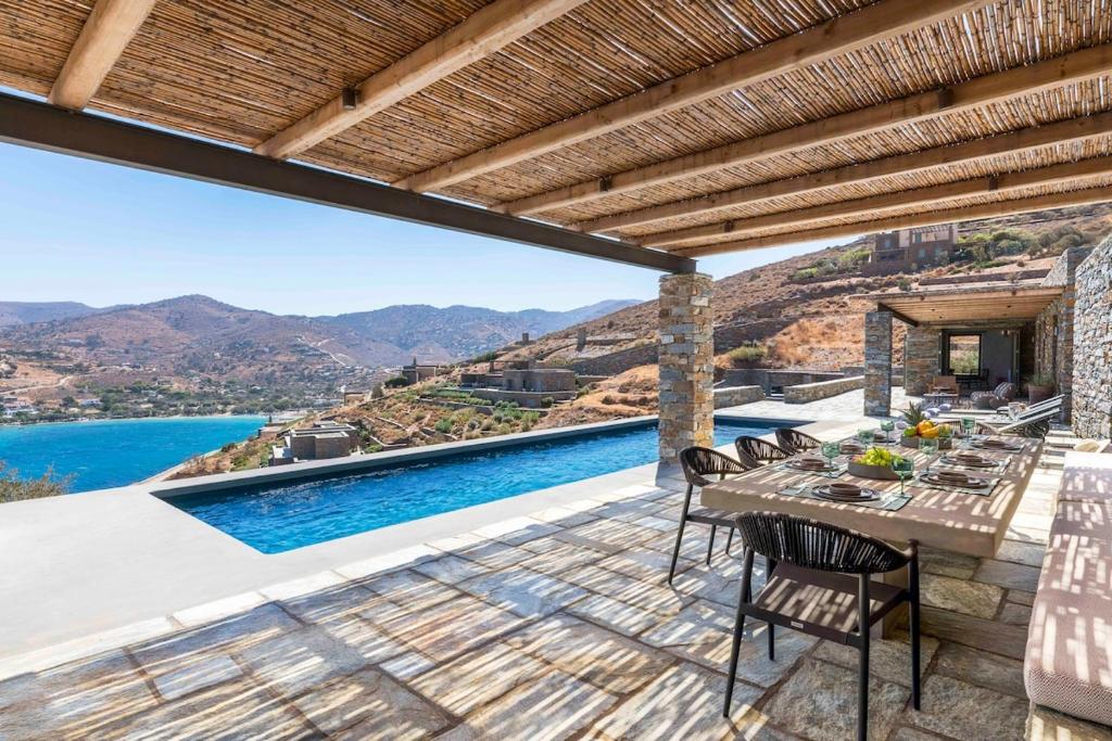 a patio with a table and chairs and a swimming pool at Lithi House in Grionísi