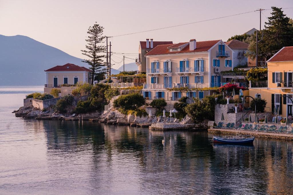a group of houses and a boat in the water at Irini's Bayside Loft in Fiskardo