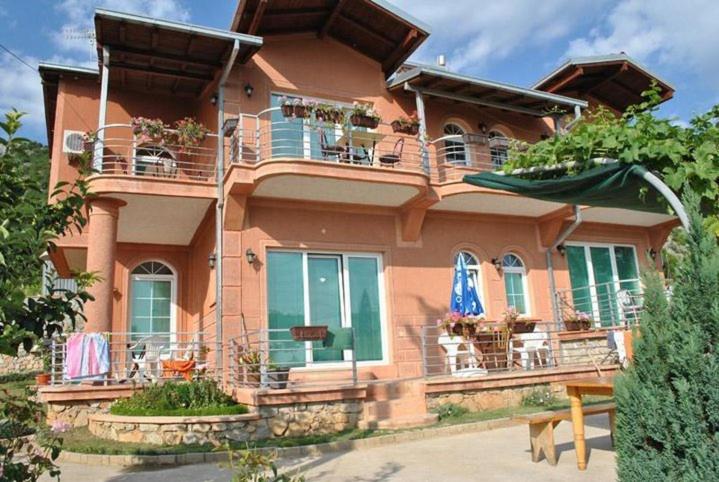 a large pink house with chairs on the balcony at Vila Anastas in Ohrid