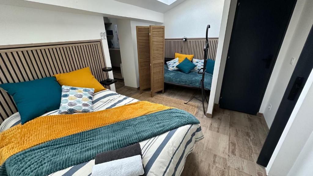 a bedroom with a bed with blue and yellow pillows at Family in Calais