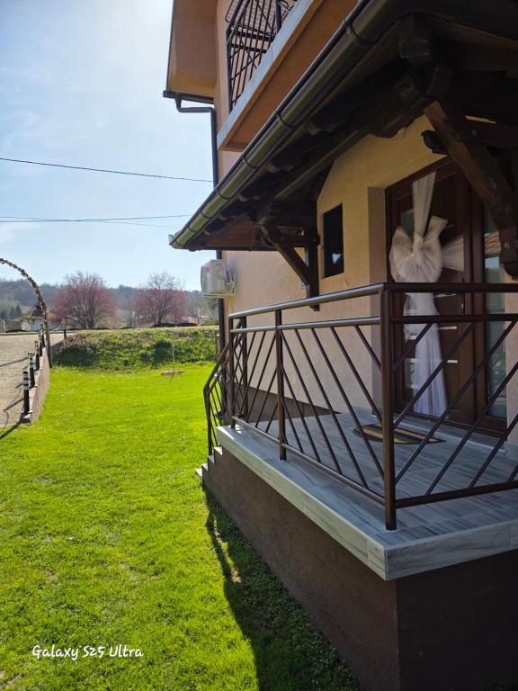 a balcony of a house with a green field at Sobe IVANA in Gornja Toplica