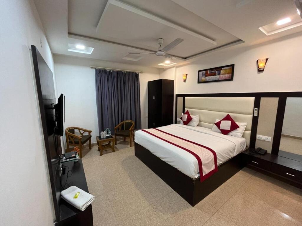 a hotel room with a bed and a television at Hotel Grand Father in Agra