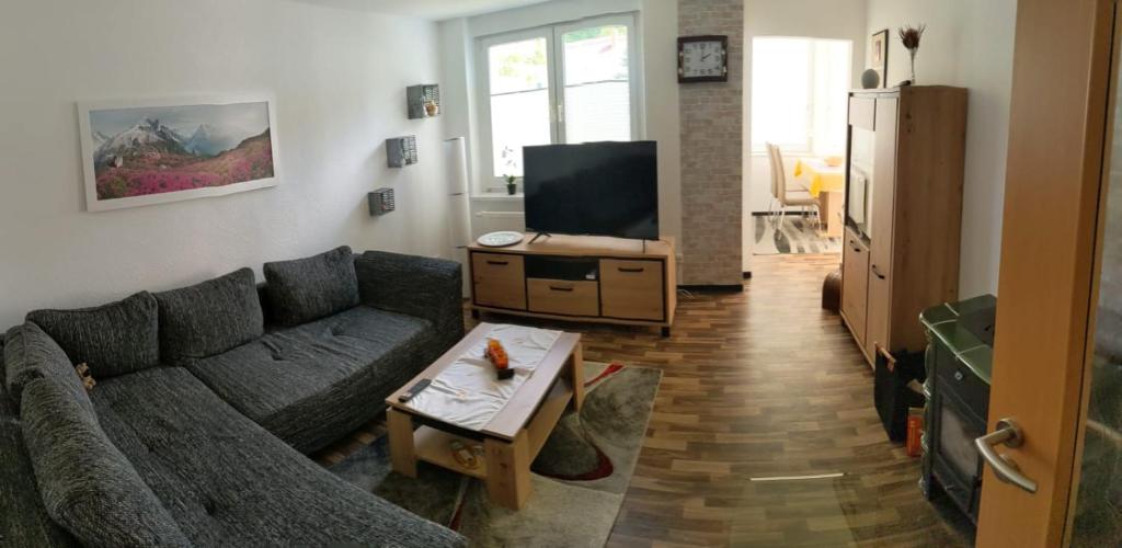 a living room with a couch and a tv at Apfelhof Rüdersdorf in Rüdersdorf