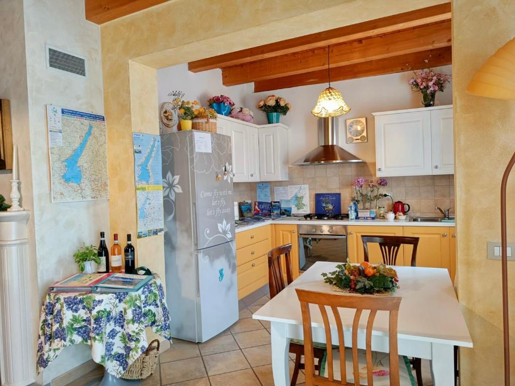 a kitchen with a table and a refrigerator at Camera Lucy in Bardolino