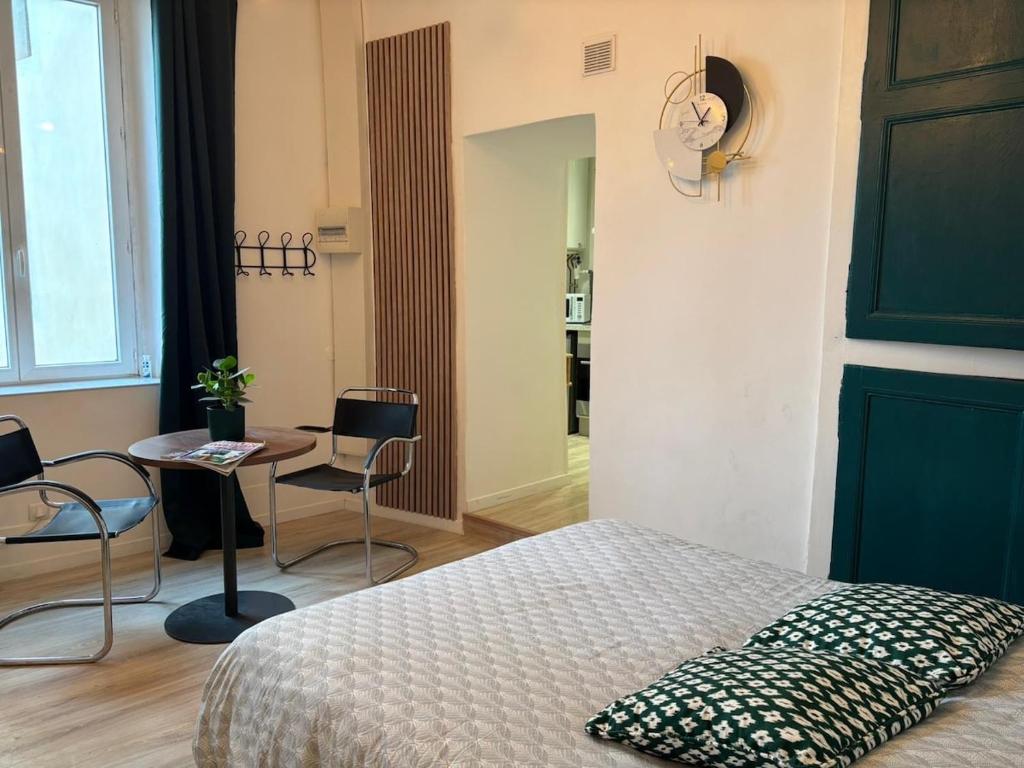 a bedroom with a bed and a table and chairs at Le refuge in Bellême