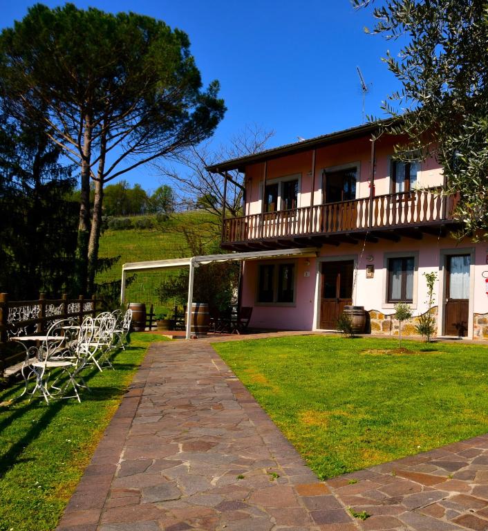 a house with white chairs in the yard at Tenuta Valdomini in Attimis
