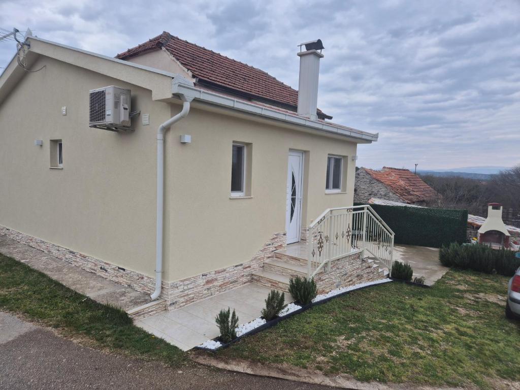 a white house with a staircase in front of it at Kuca za odmor Toma in Ljubuški