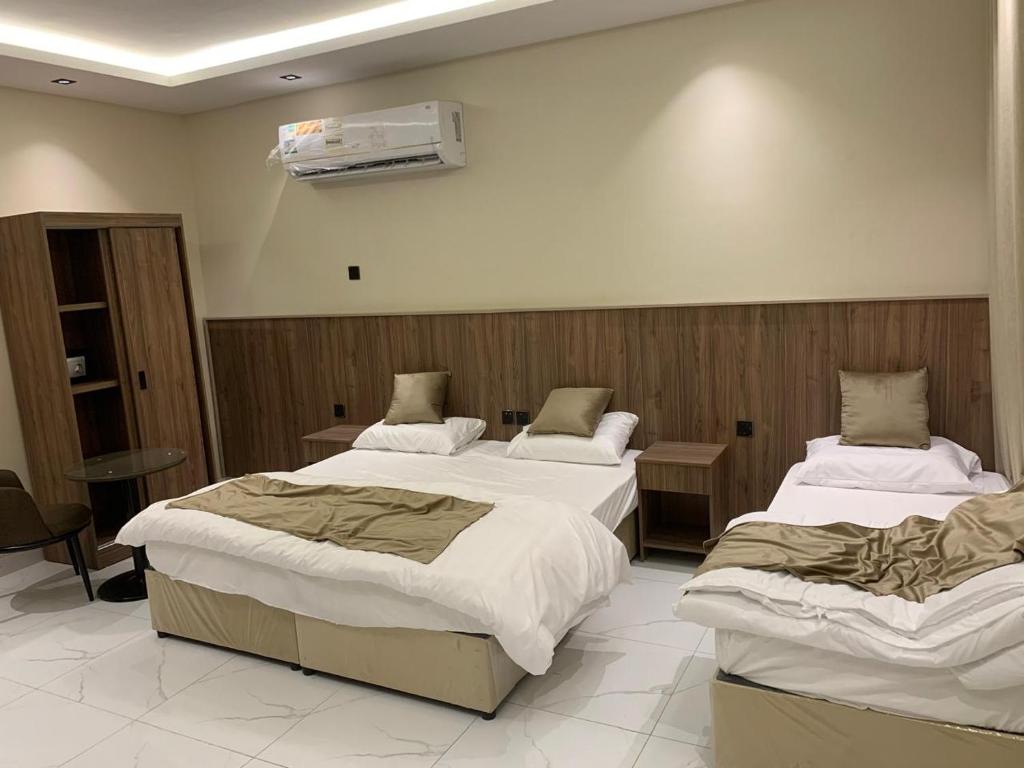 a room with three beds in a room at منازل الثقة in An Nikāshah