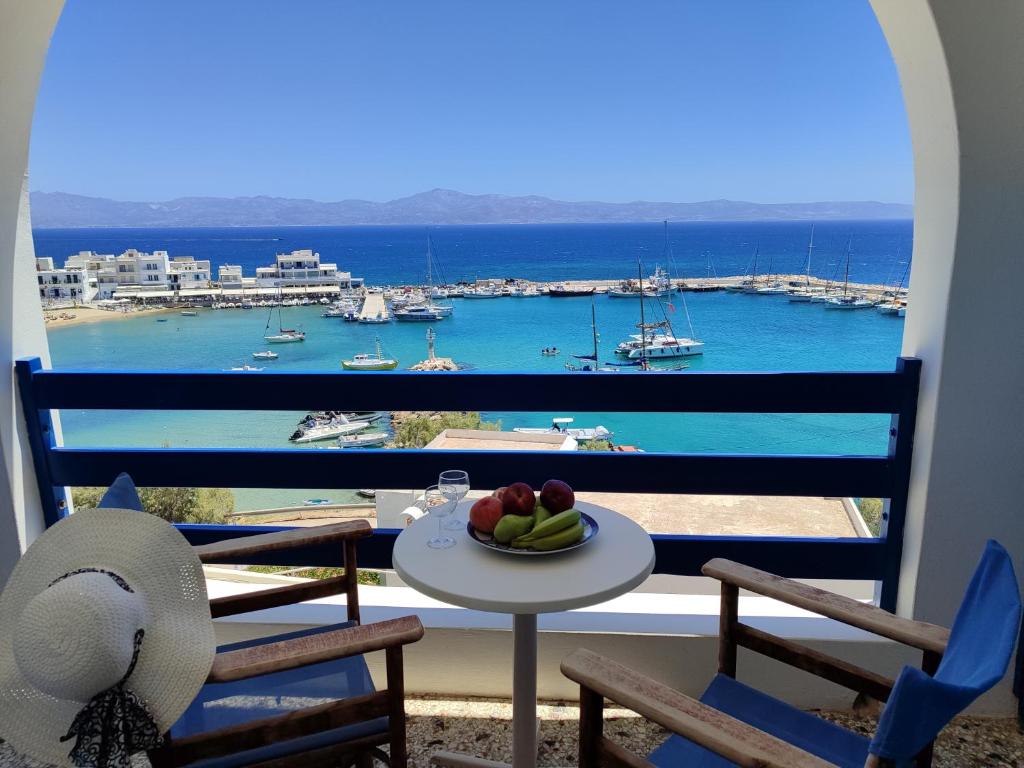 a table with a bowl of fruit on a balcony at Corali Hotel in Piso Livadi