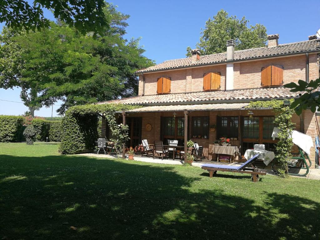a large house with a table and chairs in the yard at Il Giardino di Dede in Ferrara