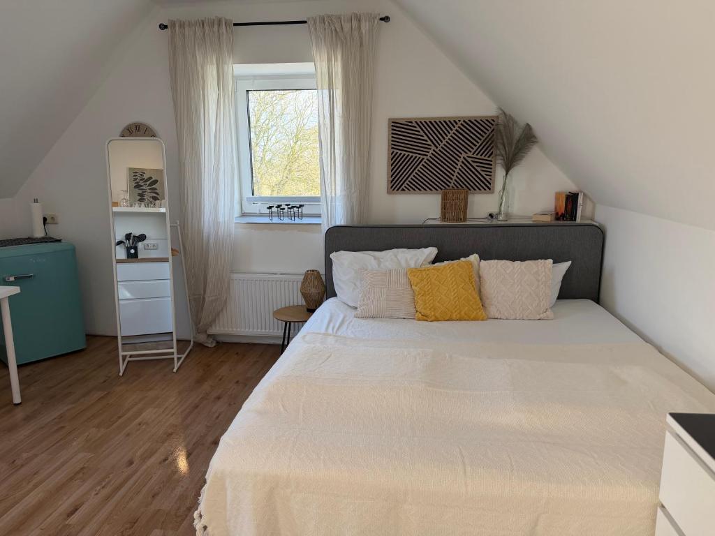 a bedroom with a large bed and a window at Deich Winde 9.1 in Dorum-Neufeld