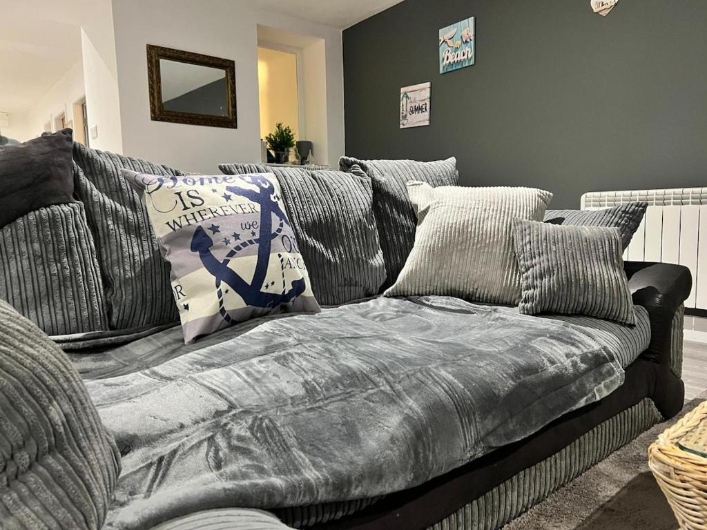 a gray couch with pillows in a living room at Pool table-Pet Friendly-Beach access-Garden in Trearddur