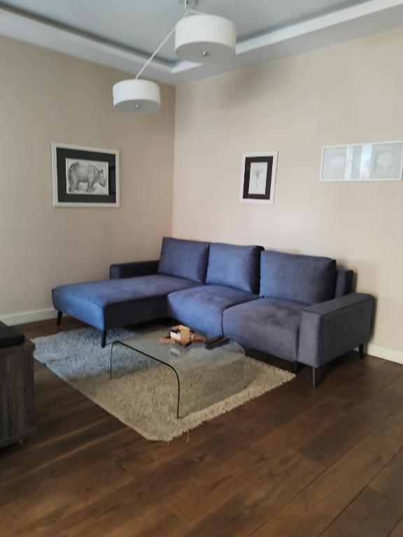 a living room with a blue couch and a table at DELUXE Apartment Newsky with terrace in Belgrade