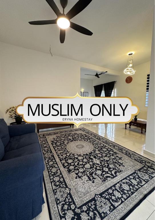 a living room with a blue couch and a rug at Eryna Homestay in Nibung Tebal