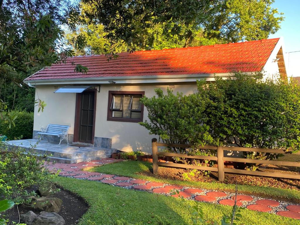 a small white house with an orange roof at Blue Crane Guesthouse in Hilton