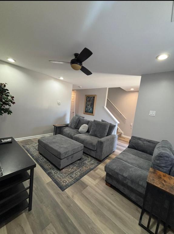 a living room with two couches and a ceiling fan at Riverside Retreat in Camden