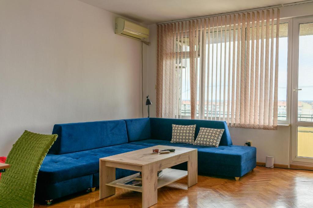 a blue couch in a living room with a table at MIA Apartment in Yambol