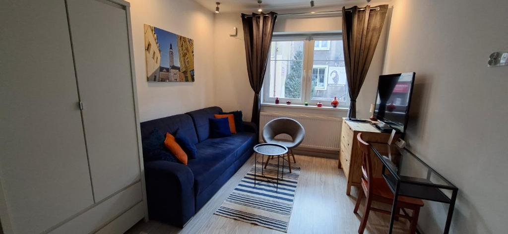 a living room with a blue couch and a window at 91 kroków - 91 steps free parking in Bolesławiec