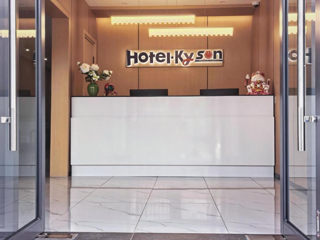 a lobby with a white reception desk in a building at Hotel Kyson 凯森酒店 in Cocody