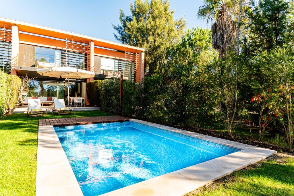 a swimming pool in the backyard of a house at Troia Ocean Breeze Villa in Troia