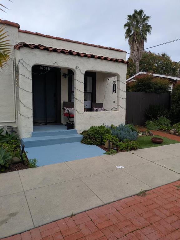 a small white house with a palm tree in a yard at Casa Dorado - Bright, Sunny 2 Bedroom 1 Bath House - Fenced Yard, Private Patio in Santa Barbara