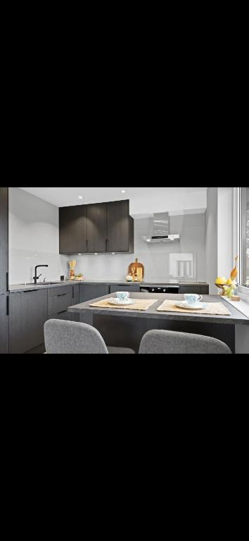 a kitchen with a table and chairs and a counter at Sentral og moderne base i Lofoten in Vestvågøya