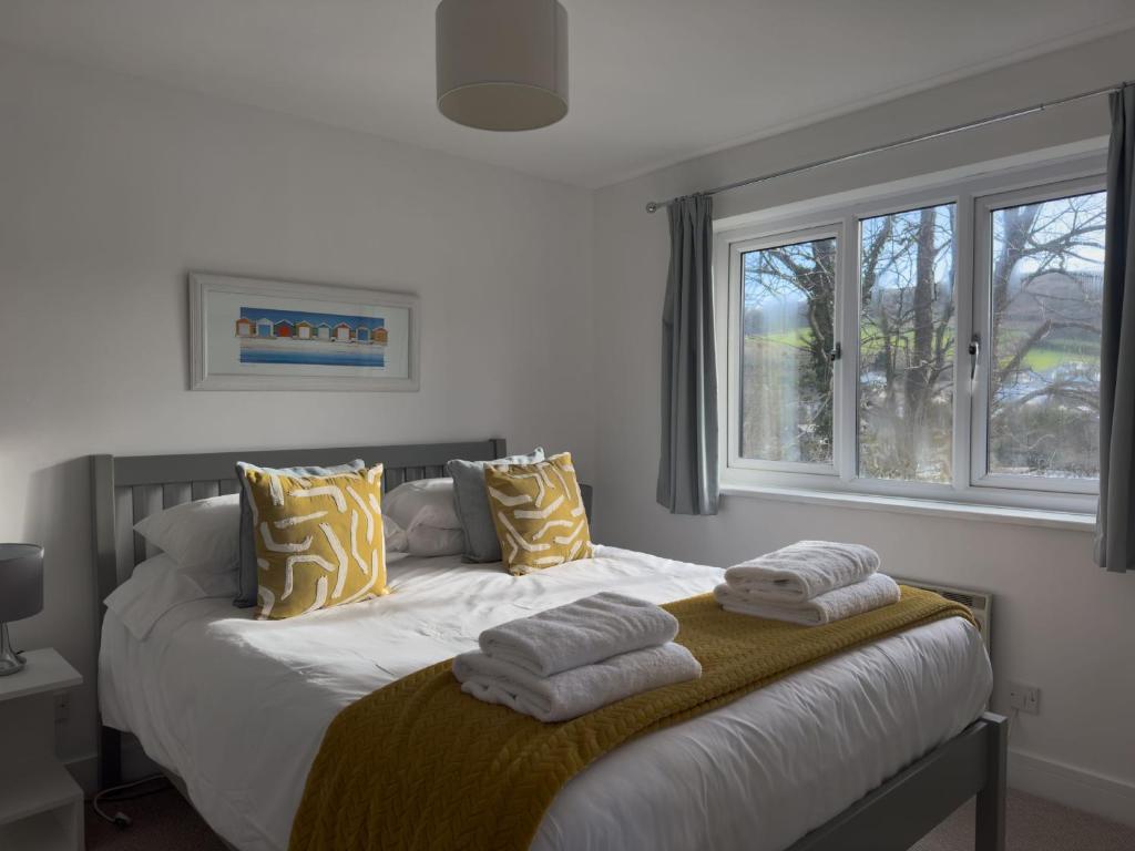 a bedroom with a bed with towels on it at Beachcomber in Croyde