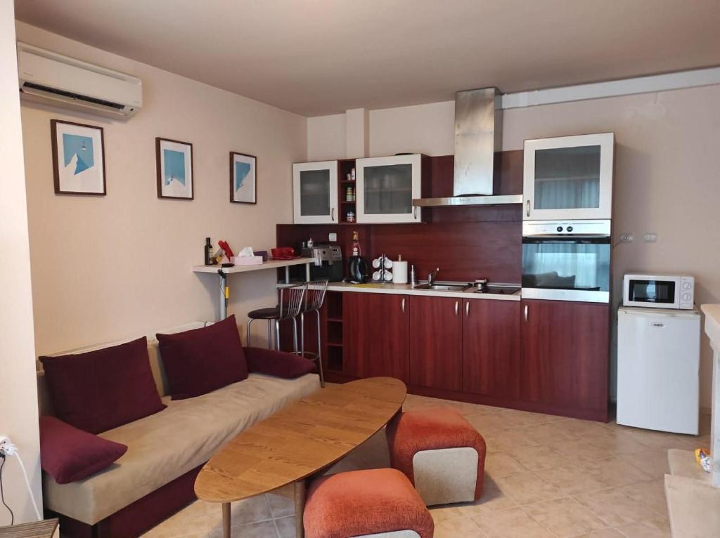 a living room with a couch and a table in a kitchen at Апартамент за гости Манчев in Stoykite