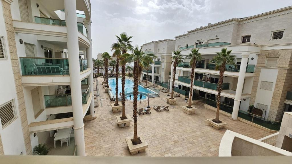 an aerial view of a hotel with a pool and palm trees at Orins place eilat in Eilat