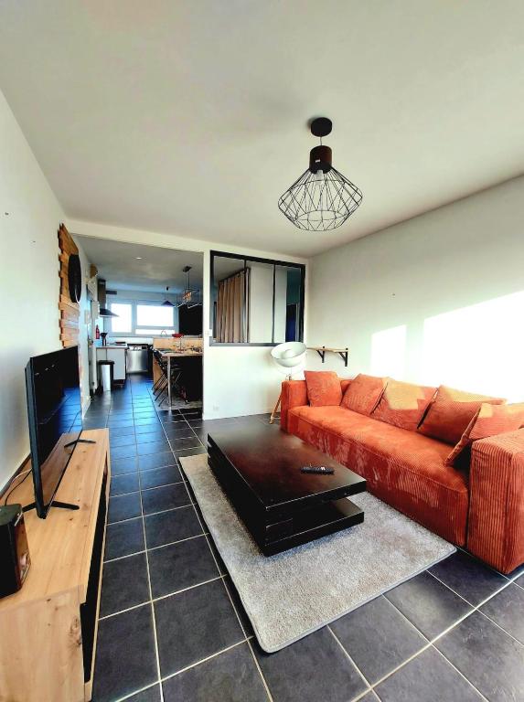 a living room with a red couch and a table at Appartement à Limoges, proche CHU in Limoges