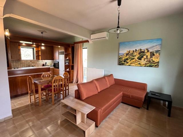a living room with a couch and a table and a kitchen at Dream Village Mani in Karvelás