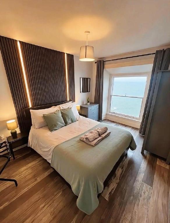 a bedroom with a large bed and a window at two bed Seafront apartment - sea views in Aberystwyth
