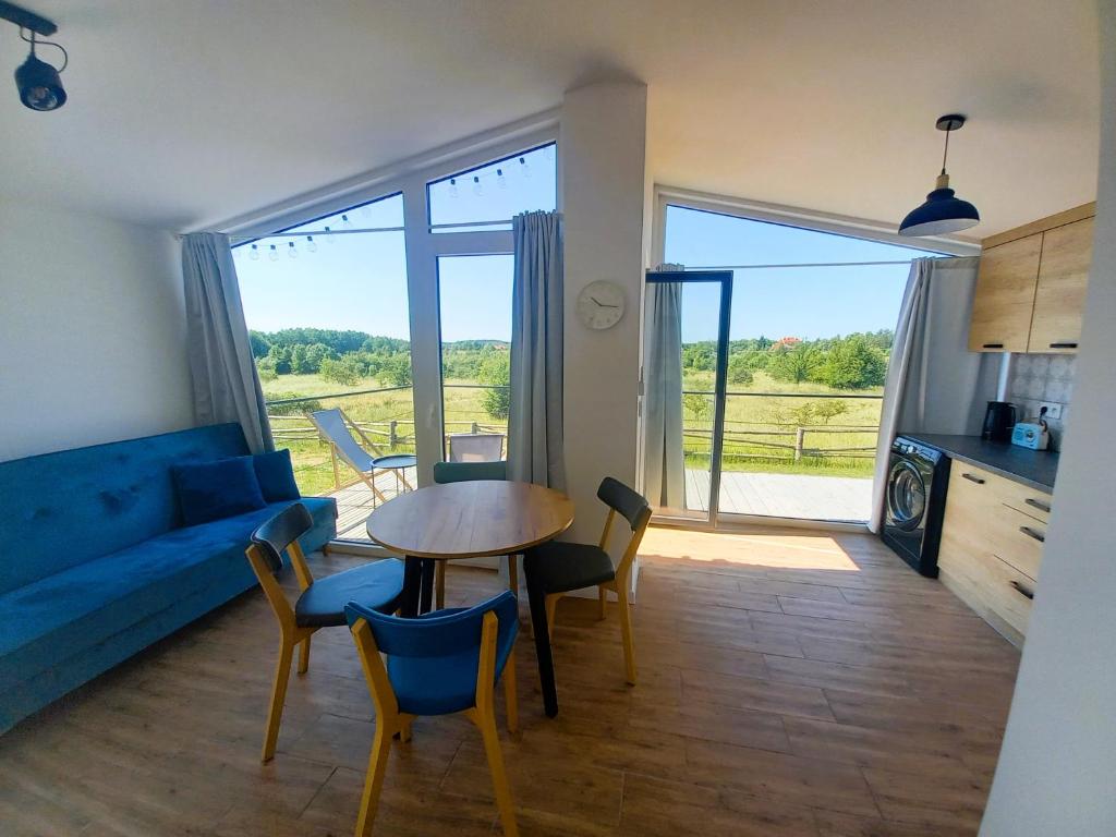 a living room with a blue couch and a table with chairs at Między Jeziorami in Ogonki