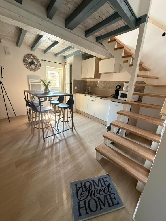 a kitchen and dining room with a dining table and stairs at La maisonnette in Coulombs