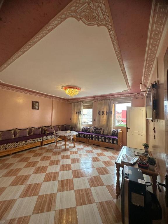 a large living room with a couch and a table at Appartement champs élyséen in Berkane