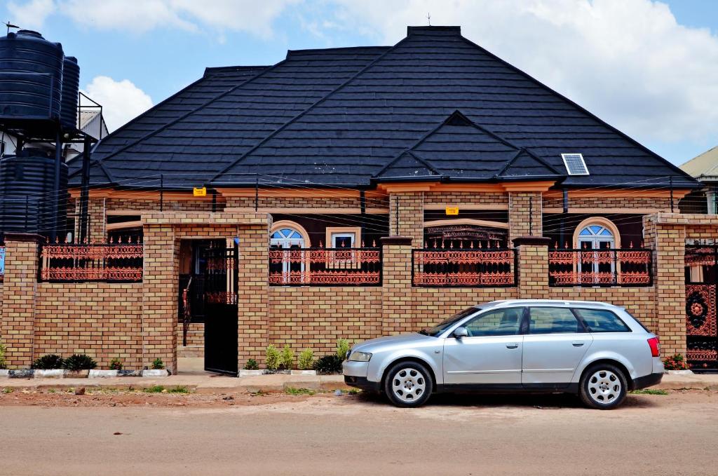 a silver car parked in front of a brick building at New Benin Home in Benin City