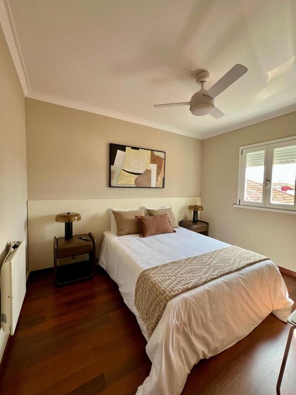 a bedroom with a bed and a ceiling fan at Private Room in Old Town in Viana do Castelo